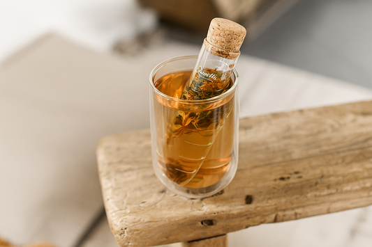Un infuseur en verre dans une tasse d'eau chaude